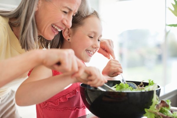 Abuela y nieta preparando una ensalada
