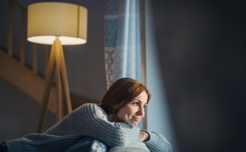 Mujer pensativa mirando hacia la ventana