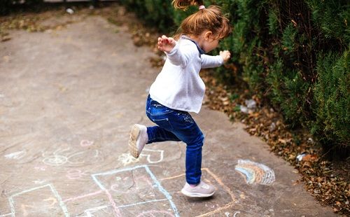 Una niña juega a la rayuela